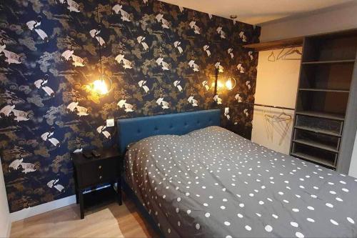 een slaapkamer met een bed met bloemenbehang bij Le SPA de l’Impasse in Limoges