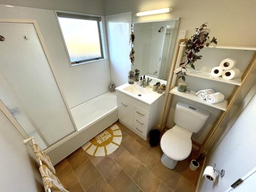 a bathroom with a shower and a toilet and a sink at Papamoa Two Rooms & Kitchenette - Dogs welcome in Papamoa