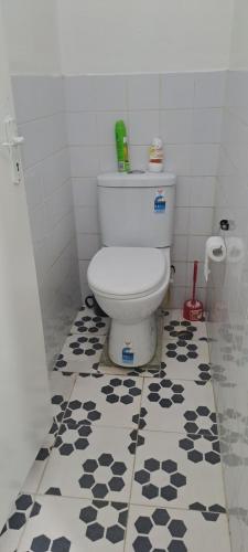 a bathroom with a toilet with a black and white floor at ABM Court Apartments in Nadi