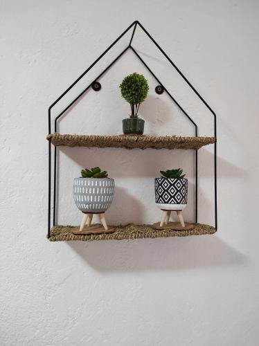 a mirror hanging on a wall with two plants at City Center Stay in Visoko