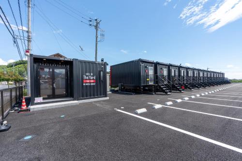 une rangée de conteneurs noirs dans un parking dans l'établissement HOTEL R9 The Yard Tomioka, à Tomioka
