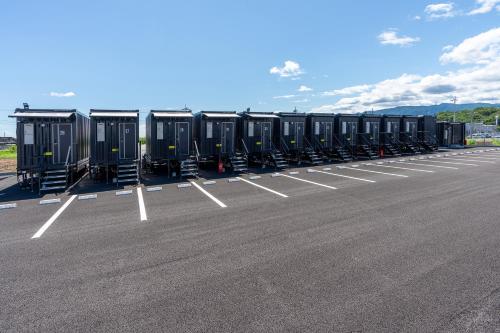 a row of black containers sitting in a parking lot at HOTEL R9 The Yard Tomioka in Tomioka