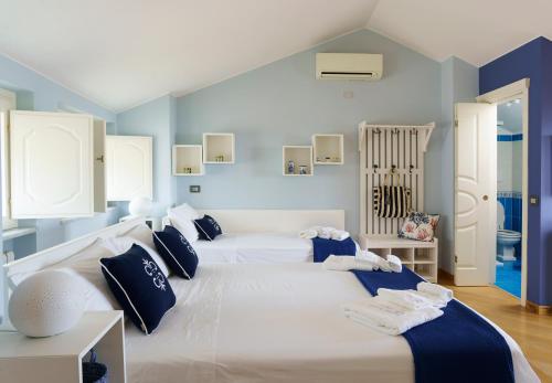 una camera con 2 letti bianchi e pareti blu di Suite Aphrodite - Exclusive Flat a Salerno