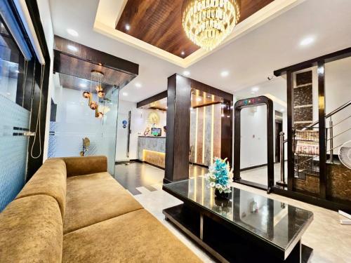ein Wohnzimmer mit einem Sofa und einem Glastisch in der Unterkunft Hotel Cosmo - Karol Bagh in Neu-Delhi