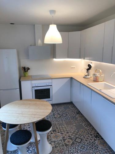 a kitchen with a wooden table and a table and stool at Maison familiale 100m2 in Witry-lès-Reims