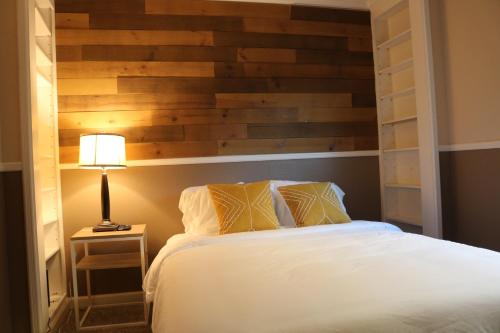 a bedroom with a bed with a wooden wall at Serene Waterside Retreat in Discovery Bay