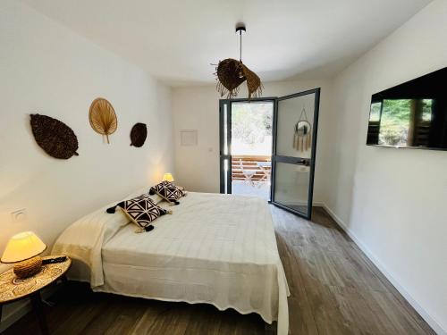 a bedroom with a bed and a table and a mirror at Hôtel Résidence CAPENSE in Centuri