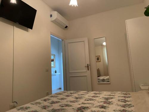 een slaapkamer met een bed en een spiegel bij Casa di Paolino in Porto Valtravaglia