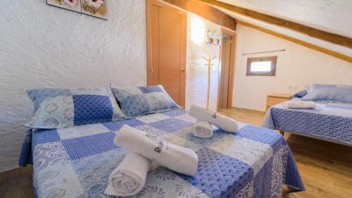 - une chambre avec 2 lits avec des draps bleus et blancs dans l'établissement Villa Sol Alozaina by Ruralidays, à Alozaina