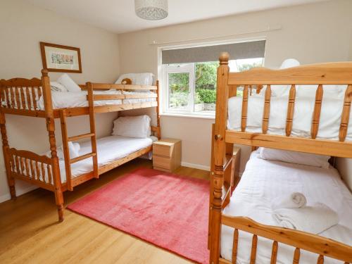 a bedroom with two bunk beds and a window at Manor Cottage in Embleton