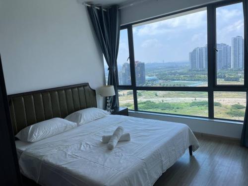 une chambre avec un lit avec des draps blancs et une grande fenêtre dans l'établissement Forest city Ataraxia park homestay, à Johor Bahru