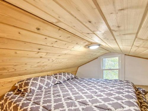 Cama en habitación con techo de madera en Casey Paradise Tiny Home Mountain Retreat, en Cullowhee