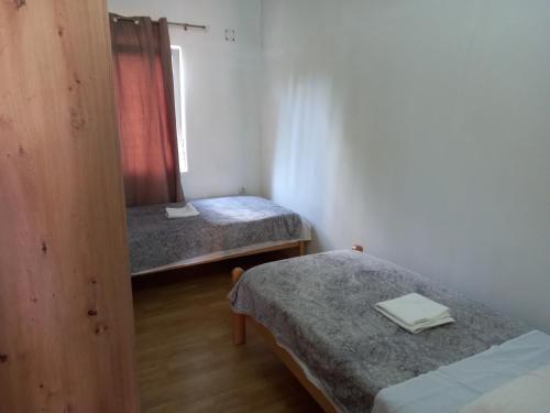 um pequeno quarto com 2 camas e uma janela em Apartman Malahov em Posedarje