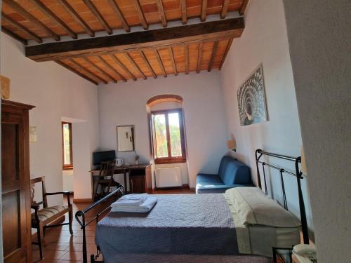 ein Schlafzimmer mit einem Bett und einem Stuhl in einem Zimmer in der Unterkunft Hotel Ristorante Casa Volpi in Arezzo