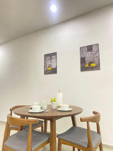 a wooden table with two chairs and a table with two cups at JOVIAL Modern Cozy Suite `Metropol BM BandarPerda in Bukit Mertajam