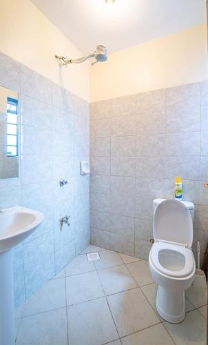 a bathroom with a toilet and a sink at Lux Suites Cavendish Square Apartments in Syokimau
