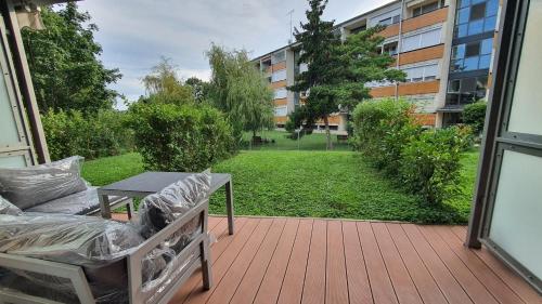 a porch with a couch and a table and a yard at Silver DeLux Apartman in Balatonfüred