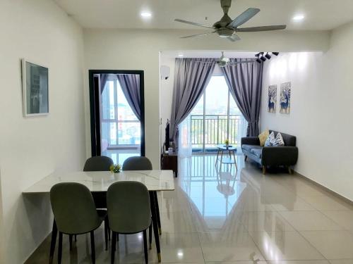 a living room with a table and chairs and a couch at JOVIAL Modern Cozy Suite `Metropol BM BandarPerda in Bukit Mertajam