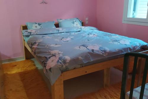 Bett mit blauer Decke in einem Zimmer in der Unterkunft Σουίτα στην εξοχική βίλλα Δημήτριος Τάκης . in Ioannina