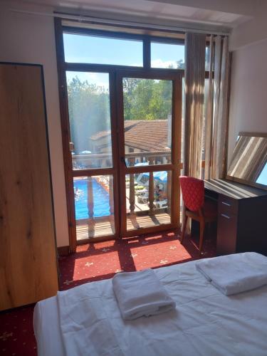 a bedroom with a bed and a view of a pool at Хотел Макензен in Melnik