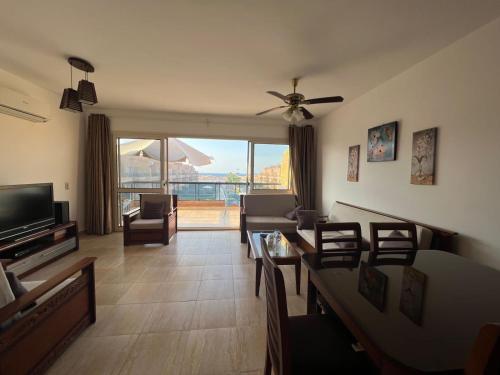 a living room with a couch and a ceiling fan at Blumar north coast in Sīdī ‘Abd ar Raḩmān