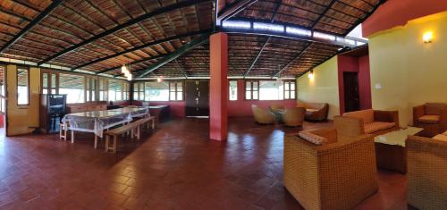 a living room with a table and some chairs at LABDHI RESORTS Stag Groups not allowed in Masinagudi