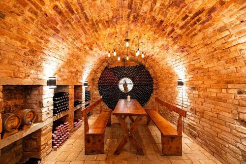 a wine cellar with a wooden table in a brick wall at Nevinný sklep in Znojmo