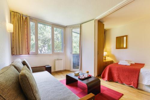 een hotelkamer met een bank en een bed bij Chamonix Sud - Chamois Blanc 110 - Happy Rentals in Chamonix-Mont-Blanc