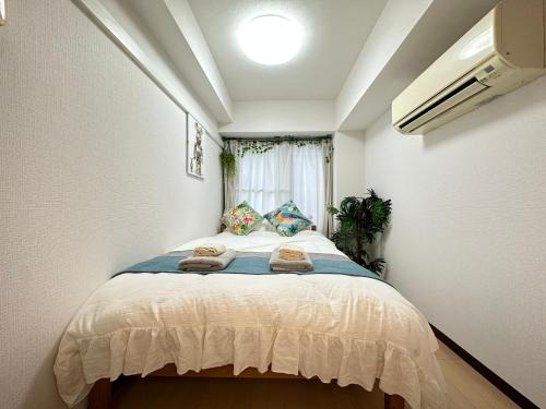 a bedroom with a bed with towels on it at nestay apartment tokyo itabashi in Tokyo