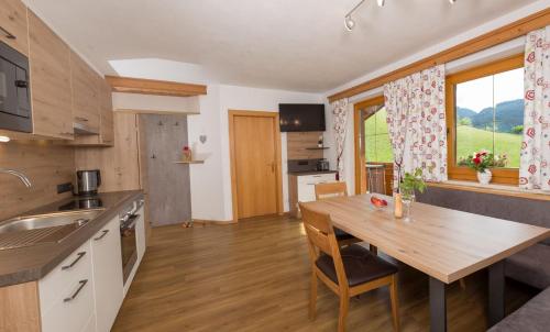 a kitchen and dining room with a wooden table at Lochgrubgut in Altenmarkt im Pongau