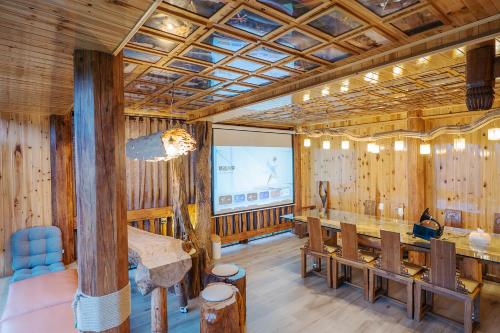 a conference room with a projection screen and wooden walls at Longji One Art Hotel in Longsheng