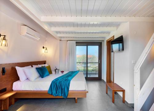 um quarto com uma cama e uma varanda com uma televisão em Melia Villas em Ierissos