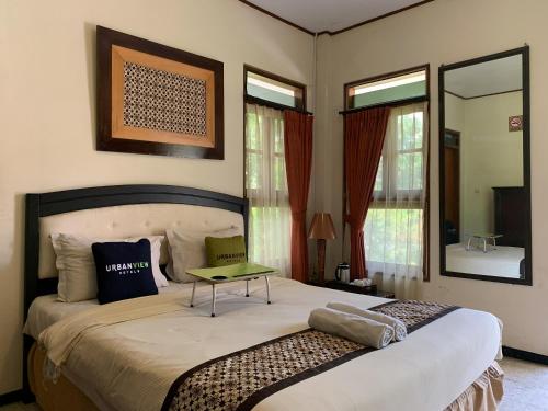 a bedroom with a bed with a table on it at Urbanview Sasono Putro Condoongcatur by RedDoorz in Yogyakarta