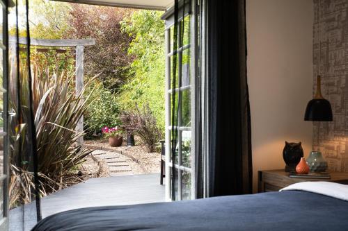 a bedroom with a view of a garden through a sliding glass door at East Street Datlesford in Daylesford