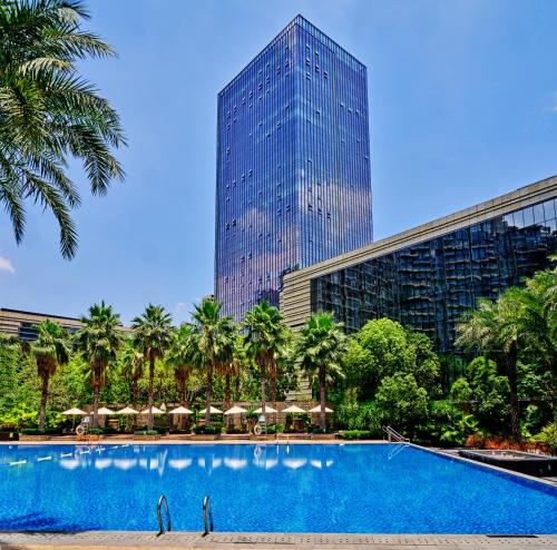 a swimming pool in front of a tall building at DoubleTree by Hilton Heyuan in Heyuan