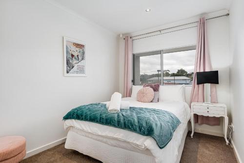 a bedroom with a bed with a window at Gallery 10 with views, pool and tennis court in Victor Harbor