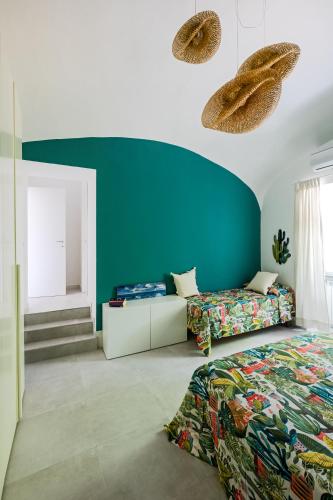 a bedroom with two beds and a blue wall at Zagara 139 in Ischia Town