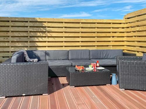 a patio with a couch and two chairs and a table at 8 person holiday home in Bølandet-By Traum in Røyra
