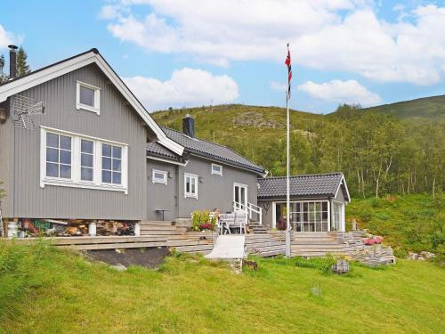 a gray house with a flag on a deck at 6 person holiday home in Sandhornøy-By Traum in Røssnes