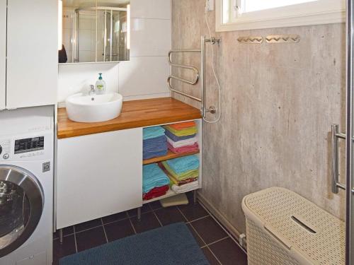 ein Badezimmer mit einem Waschbecken und einer Theke mit Handtüchern in der Unterkunft Holiday home Sandhornøy II in Røssnes