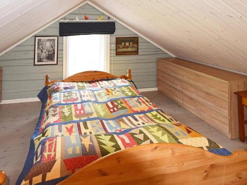 1 dormitorio con 1 cama con edredón en Holiday home Sandhornøy II, en Røssnes