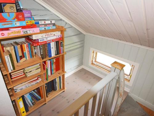 a staircase with a book shelf filled with books at 6 person holiday home in Sandhornøy-By Traum in Røssnes