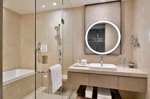 a bathroom with a sink and a shower and a mirror at Marriott Executive Apartments Navi Mumbai in Navi Mumbai