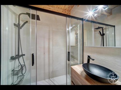 a bathroom with a sink and a glass shower at CASA CORILHA de Alma de Nieve in Salardú