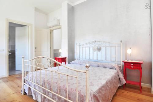 クアルト・ダルティーノにあるAgriturismo Colomberaのベッドルーム1室(白いベッド1台、赤いテーブル2台付)