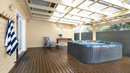 a hot tub on a deck with a pergola at River Shack in Shoalhaven Heads
