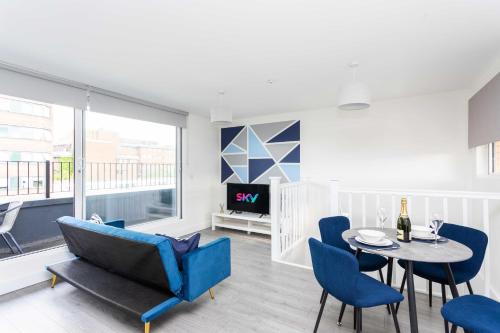 a living room with a blue couch and a table and chairs at Free Parking - City Centre - Sky & Netflix in Hemel Hempstead