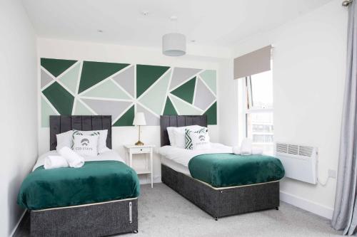 two beds in a room with green and white at 20 Percent Off Monthly Stays - City Centre - Sky & Netflix in Hemel Hempstead