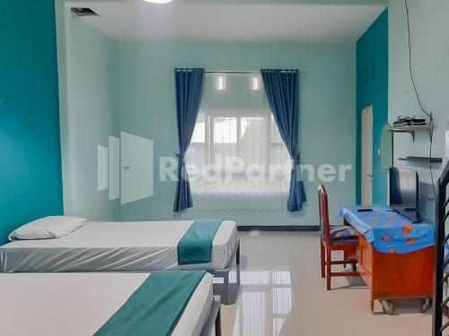 a hospital room with two beds and a window at Syariah Safar Guest House Mitra RedDoorz in Cijoho