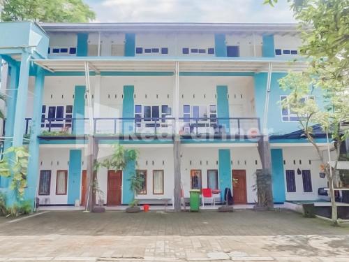 a blue and white building with a courtyard at Syariah Safar Guest House Mitra RedDoorz in Cijoho